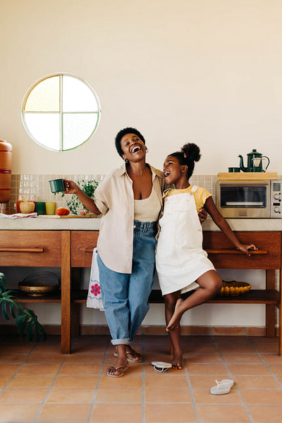 Happy mother and daughter having a fun moment in the kitchen