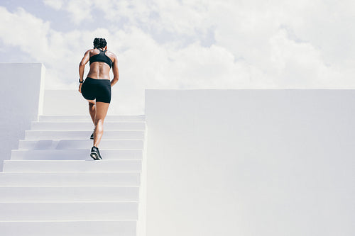 Fitness woman running up the stairs of a building