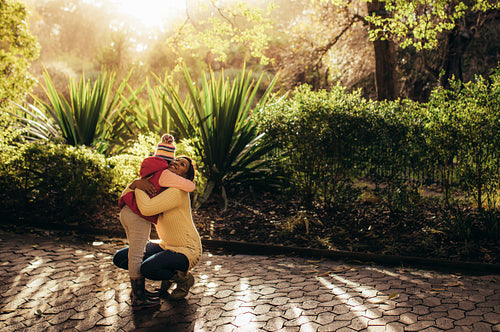 Mother and daughter embracing in the park