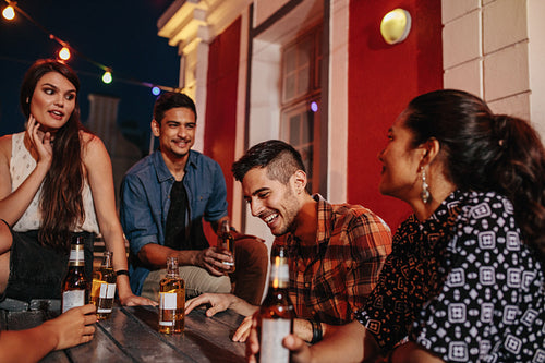 Friends sitting around a table at rooftop party