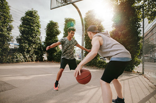 Young friends playing basketball together