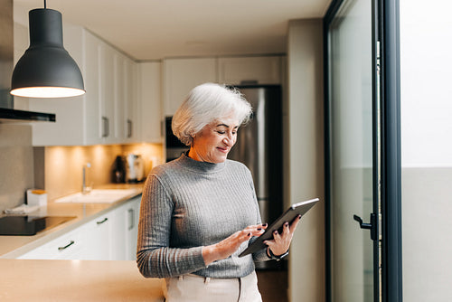 Mature woman using a digital tablet at home