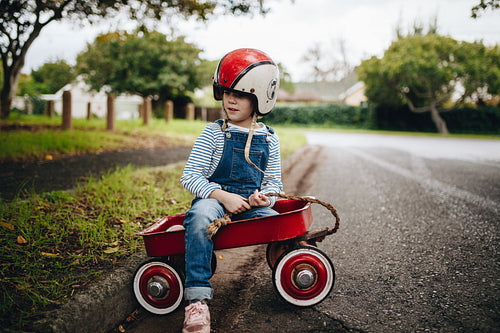 Beautiful young girl in a red wagon cart
