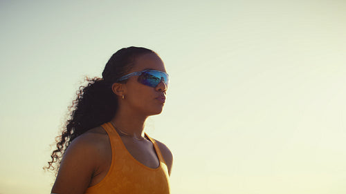 Handheld shot of talented female sportspeople playing professional beach volleyball as the sun sets
