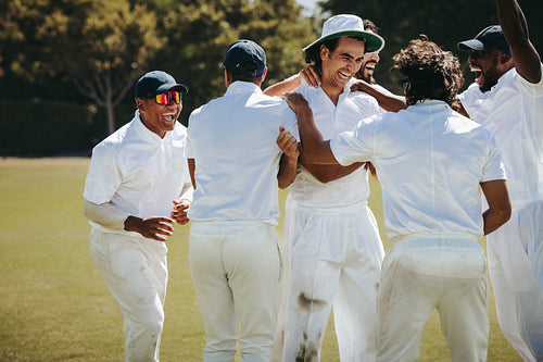 Cricket team celebrating a wicket during a fielding play