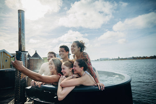 The hot tub becomes the backdrop as friends share a vacation selfie outdoors.