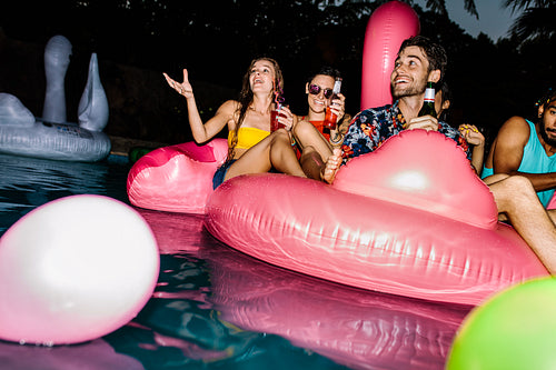 Friends enjoying pool party in evening