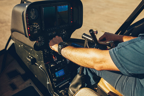 Pilot's hand on an helicopter instrument panel.