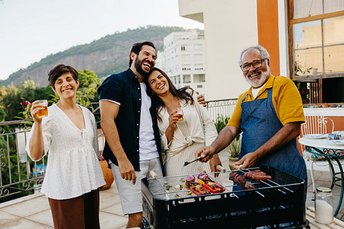 Smiling family enjoying a barbecue at a sunny outdoor gathering