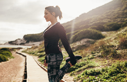 Female runner doing stretching workout outdoors