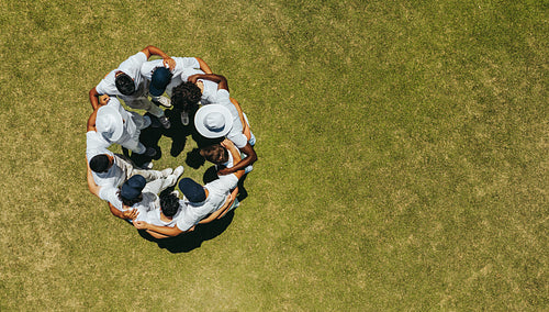 Aerial view of a cricket team huddling on the field