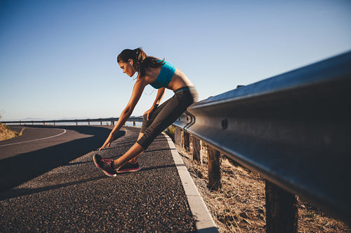 Young woman doing stretching after a run