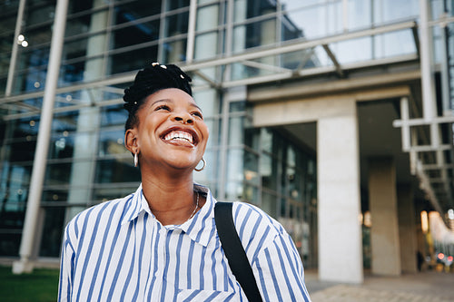 Young black businesswoman smiling happily while commuting to work in the morning