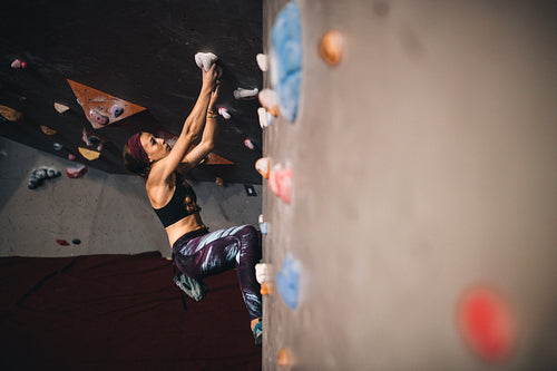 Woman climbing indoor boulder wall