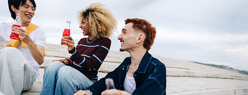 Friends laughing together outdoors sharing drinks