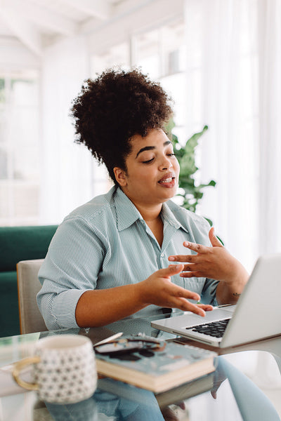 Woman at home video conferencing on laptop