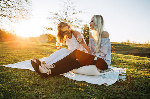 Beautiful women drinking wine in the park