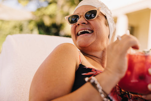 Senior woman enjoying a cocktail while on vacation