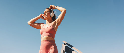 Woman listening to music while exercising outdoors