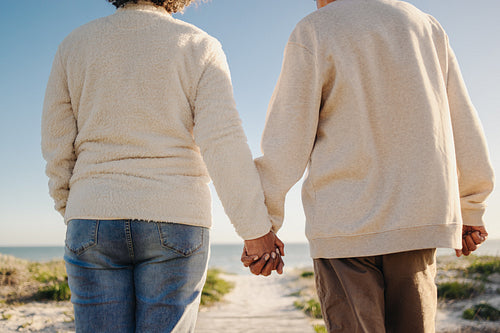 Senior couple holding hands at the beach