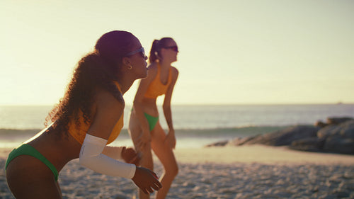 Dynamic handheld shot of female beach volleyball team celebrating victory