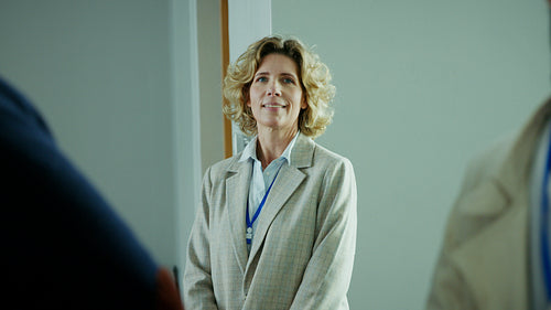 Confident businesswoman smiles warmly, ready for a productive meeting in a modern office environment