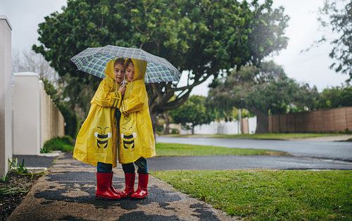 Twin sisters outdoors on a rainy day