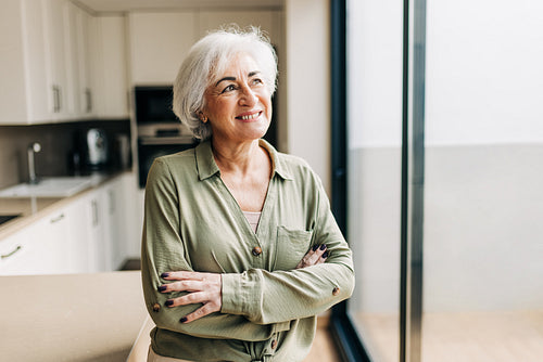 Pensive senior woman smiling cheerfully