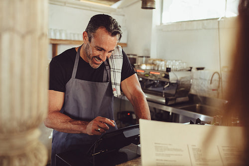 Barista entering customer order in cashbox computer