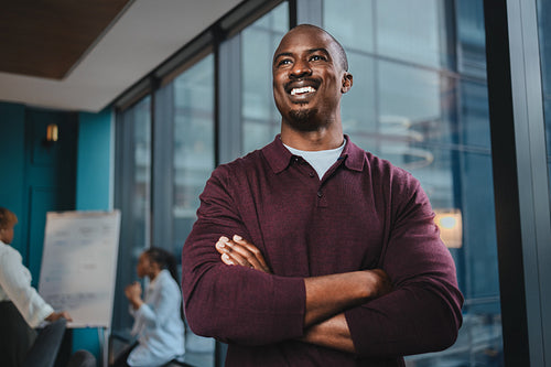 Successful professional business man with crossed arms in boardroom