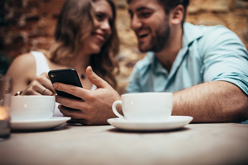 Happy couple sitting in a coffee shop talking