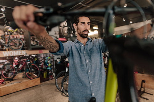 Worker inspecting a bicycle in workshop