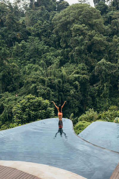 Woman with hands raised standing in swimming pool