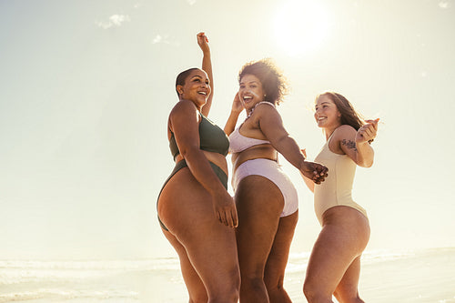 Three girlfriends dancing at the beach