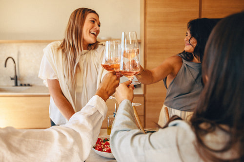 Friends sharing a toast in a cozy kitchen ambiance