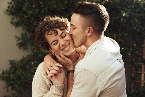 Young man kissing his girlfriend on the cheek