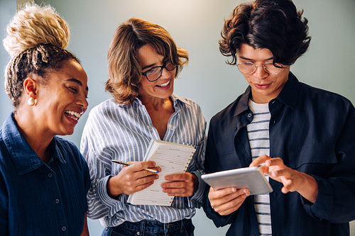 Three colleagues smiling and sharing ideas during a productive discussion