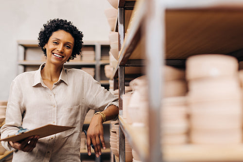 Happy ceramic store owner smiling at the camera in her shop