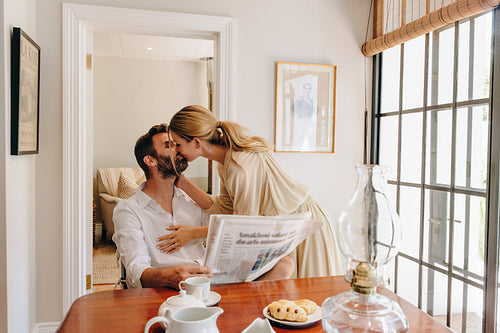 Affectionate couple kissing at the tea table