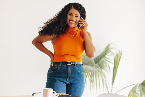 Cheerful young businesswoman speaking on the phone in an office