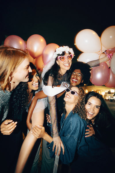 Group of friends celebrating at a night party with festive balloons