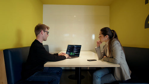 Programmers working on a code and having a discussion in an office