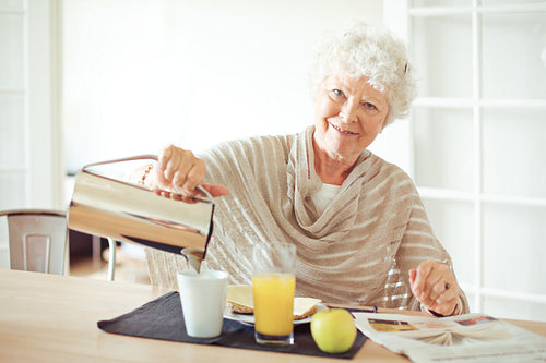 Cheerful Grandma at Home Having Breakfast