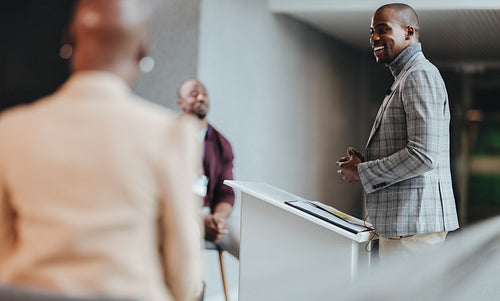 Happy businessman giving a speech at a conference