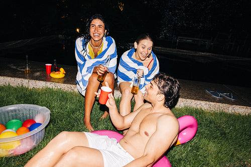 Friends enjoy night pool party with drinks