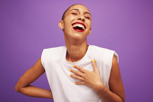 Pretty female model laughing on purple background
