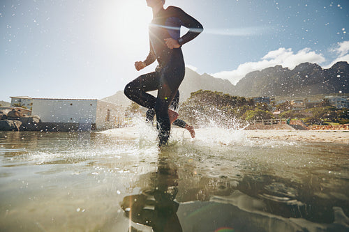 Young athlete running into water