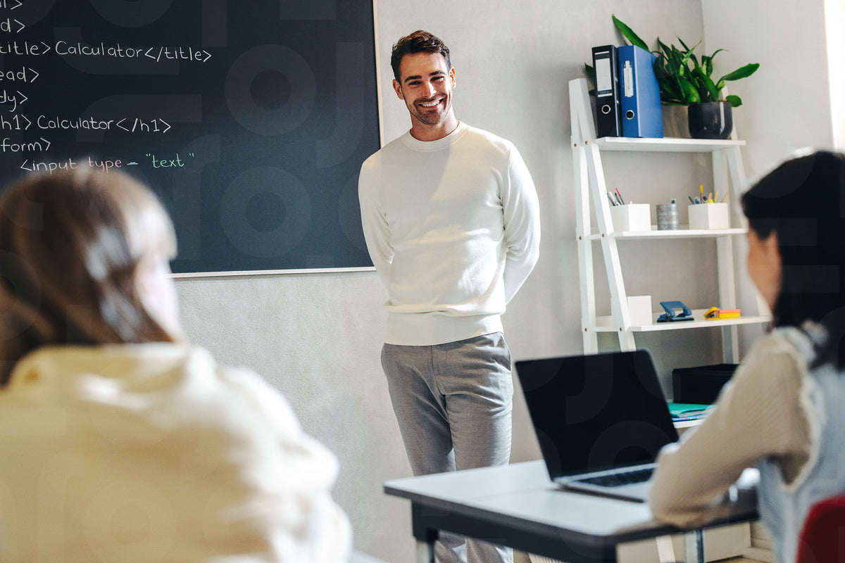 Teaching the future: Happy male teacher leading a coding class for kid ...