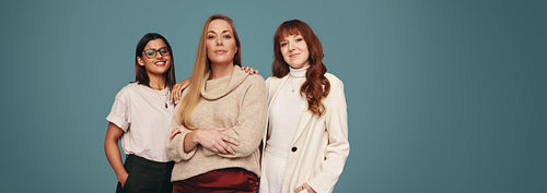 Portrait of three women looking at the camera in a studio