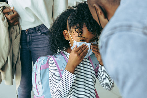 Girl in face mask at airport with family